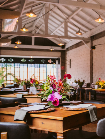 Ambiente de refeitório com várias mesas bem organizadas e enfeitadas.